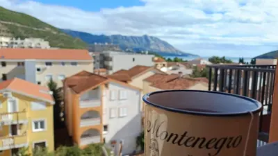 a cup of coffee on a balcony with a city at Central Sea View Studio Budva in Budva