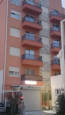an apartment building with a garage in front of it at Central Sea View Studio Budva in Budva