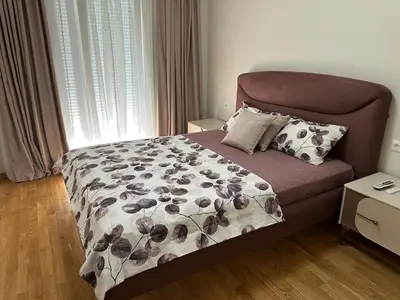 a bedroom with a bed with a floral bedspread at ViSi 10 in Podgorica