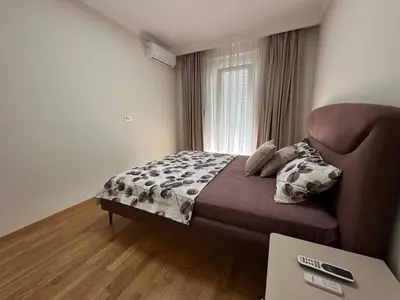 a bedroom with a bed and a couch and a table at ViSi 10 in Podgorica
