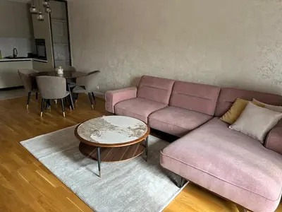 a living room with a pink couch and a table at ViSi 10 in Podgorica