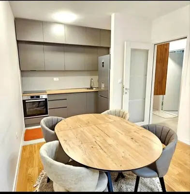 a kitchen with a wooden table and chairs at Mia Suites in Podgorica