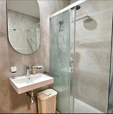 a bathroom with a sink and a glass shower at Mia Suites in Podgorica