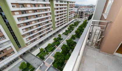 an apartment balcony with a garden of trees and buildings at Mia Suites in Podgorica