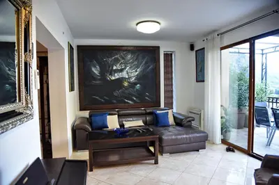 a living room with a leather couch and a table at Aky apartment in Škaljari