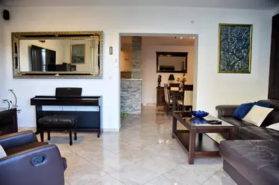 a living room with a couch and a piano at Aky apartment in Škaljari