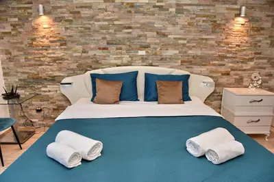 a bedroom with a large bed with towels on it at Aky apartment in Škaljari