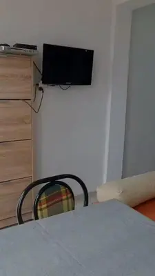 a room with a table and a chair and a refrigerator at Apartment Pinješ in Ulcinj