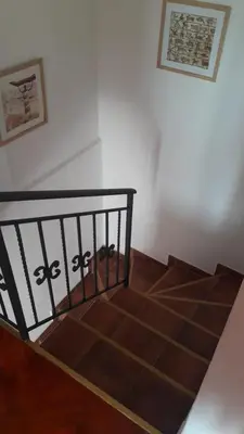 a stairwell with a black railing and a white wall at Teona-Apartments in Sutomore