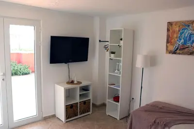 a bedroom with a television on a wall at Teona-Apartments in Sutomore