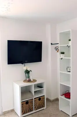 a living room with a tv on a white wall at Teona-Apartments in Sutomore