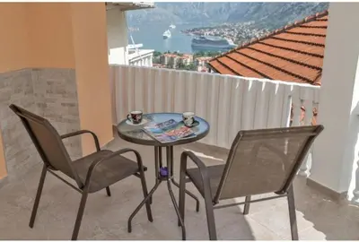 a table with two chairs and a table with two cups at Apartman Blazo in Škaljari