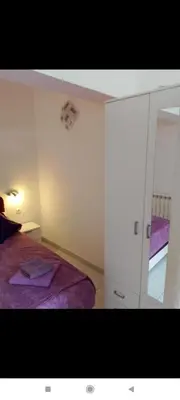 a small room with a bed and a mirror at Apartman Blazo in Škaljari