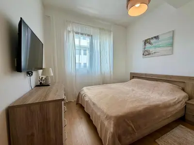 a bedroom with a bed and a flat screen tv at Comfortable City Apartment in Bar