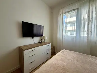 a bedroom with a television on a dresser with a window at Comfortable City Apartment in Bar