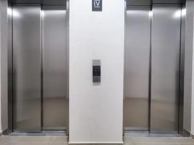 a row of metal elevator doors in a building at City Living with Style - Elegant One-Bedroom Apartment in Podgorica