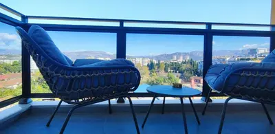 two chairs and a table on a balcony with a view at City Living with Style - Elegant One-Bedroom Apartment in Podgorica