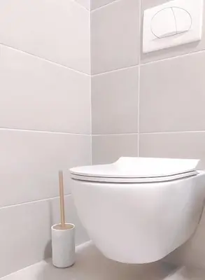 a white toilet in a bathroom with a toothbrush at City Living with Style - Elegant One-Bedroom Apartment in Podgorica