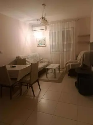 a living room with a table and a couch at Apartman 3D in Podgorica