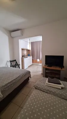 a bedroom with a bed and a flat screen tv at Simpi in Pržno