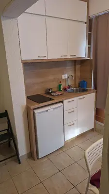 a small kitchen with white cabinets and a sink at Simpi in Pržno