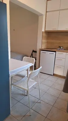 a kitchen with a table and two chairs and a refrigerator at Simpi in Pržno