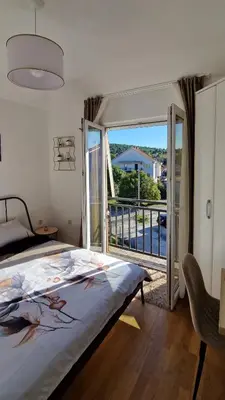 a bedroom with a bed and a balcony with a view at Mirko's home 2 Studio Apartment in Podgorica