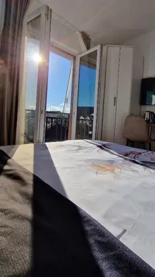a bedroom with a large bed and large windows at Mirko's home 2 Studio Apartment in Podgorica