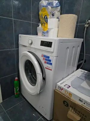 a washing machine in a bathroom with a box at Sena in Bar