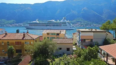 a cruise ship in the water next to some buildings at Apartment Kotor Bay in Kotor