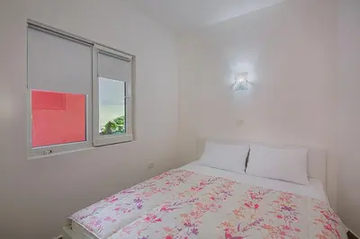 a white bedroom with a bed and a window at Apartment Kotor Bay in Kotor