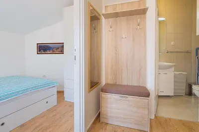 a small bedroom with a bed and a bathroom at Apartment Kotor Bay in Kotor