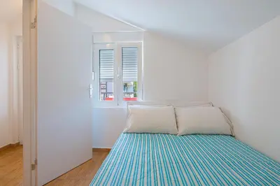 a white room with a bed and a window at Apartment Kotor Bay in Kotor