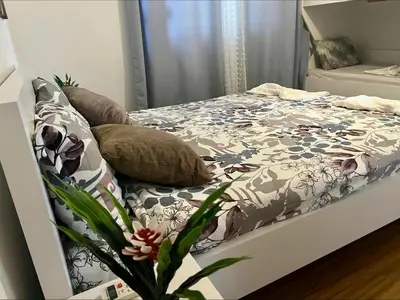 a bedroom with a bed with a floral comforter at PrivatHomeUlcinj2 in Ulcinj