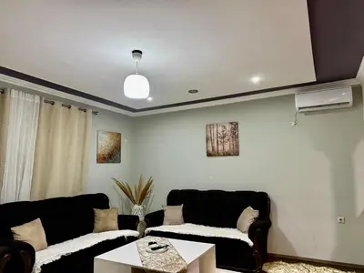 a living room with two black couches and a table at PrivatHomeUlcinj2 in Ulcinj