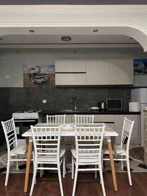 a kitchen with a white table and white chairs at PrivatHomeUlcinj2 in Ulcinj