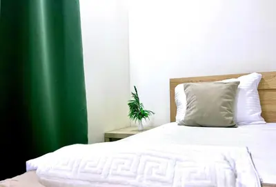 a bedroom with a white bed and a green curtain at PrivatHomeUlcinj1 in Ulcinj