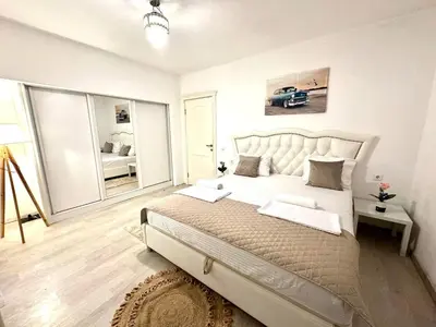 a white bedroom with a large bed and a mirror at PrivatHomeUlcinj1 in Ulcinj