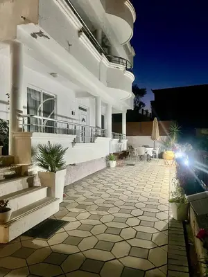 a large white house with a patio with chairs and tables at PrivatHomeUlcinj1 in Ulcinj