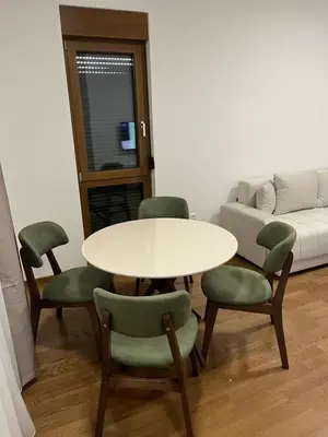 a room with a table and chairs and a couch at Apartman Lux M Residence PG in Podgorica