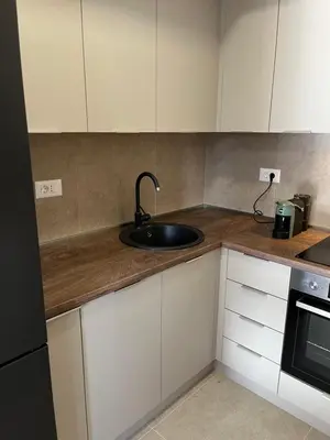 a kitchen with a sink and white cabinets at Apartman Lux M Residence PG in Podgorica