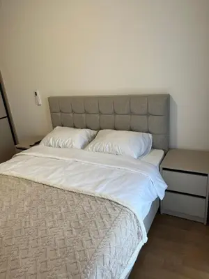 a large bed with white sheets and pillows at Apartman Lux M Residence PG in Podgorica