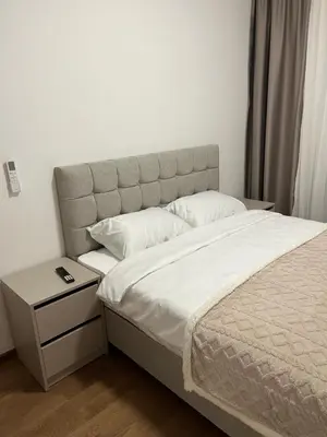 a bedroom with a bed and a nightstand next to it at Apartman Lux M Residence PG in Podgorica