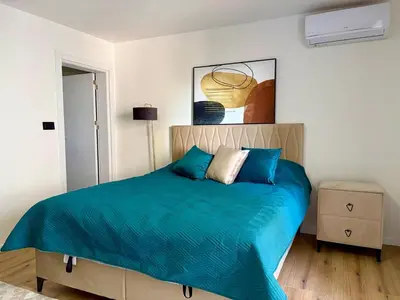 a bedroom with a large bed with blue sheets at Apartment by the sea in Dobra Voda