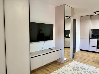 a living room with a large tv on a wall at Apartment by the sea in Dobra Voda