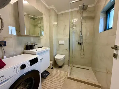 a bathroom with a shower and a toilet and a sink at Apartment by the sea in Dobra Voda