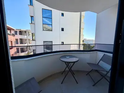 a balcony with a table and chairs on a building at Apartment by the sea in Dobra Voda