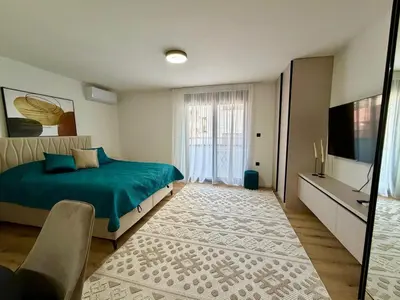 a bedroom with a green bed and a flat screen tv at Apartment by the sea in Dobra Voda