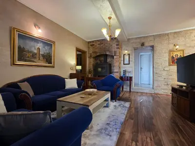 a living room with blue couches and a tv at Sicilija in Podgorica