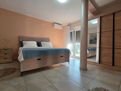a bedroom with a large bed and a large window at Sicilija in Podgorica